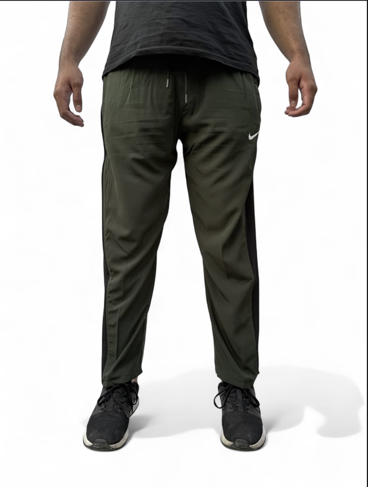 Person wearing green athletic pants with a Nike logo on a white background